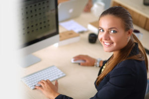 female employee smiling while at her computer